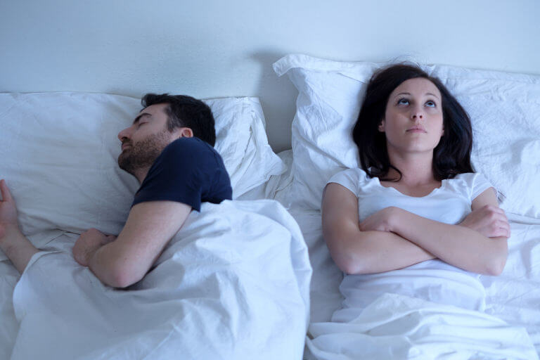 sleeping husband with annoyed wife