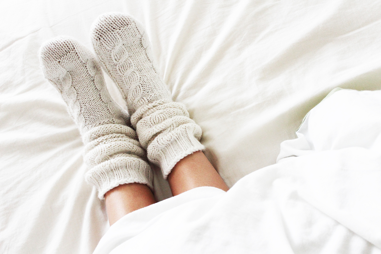 Warm feet in socks under covers, sleeping with the heat on