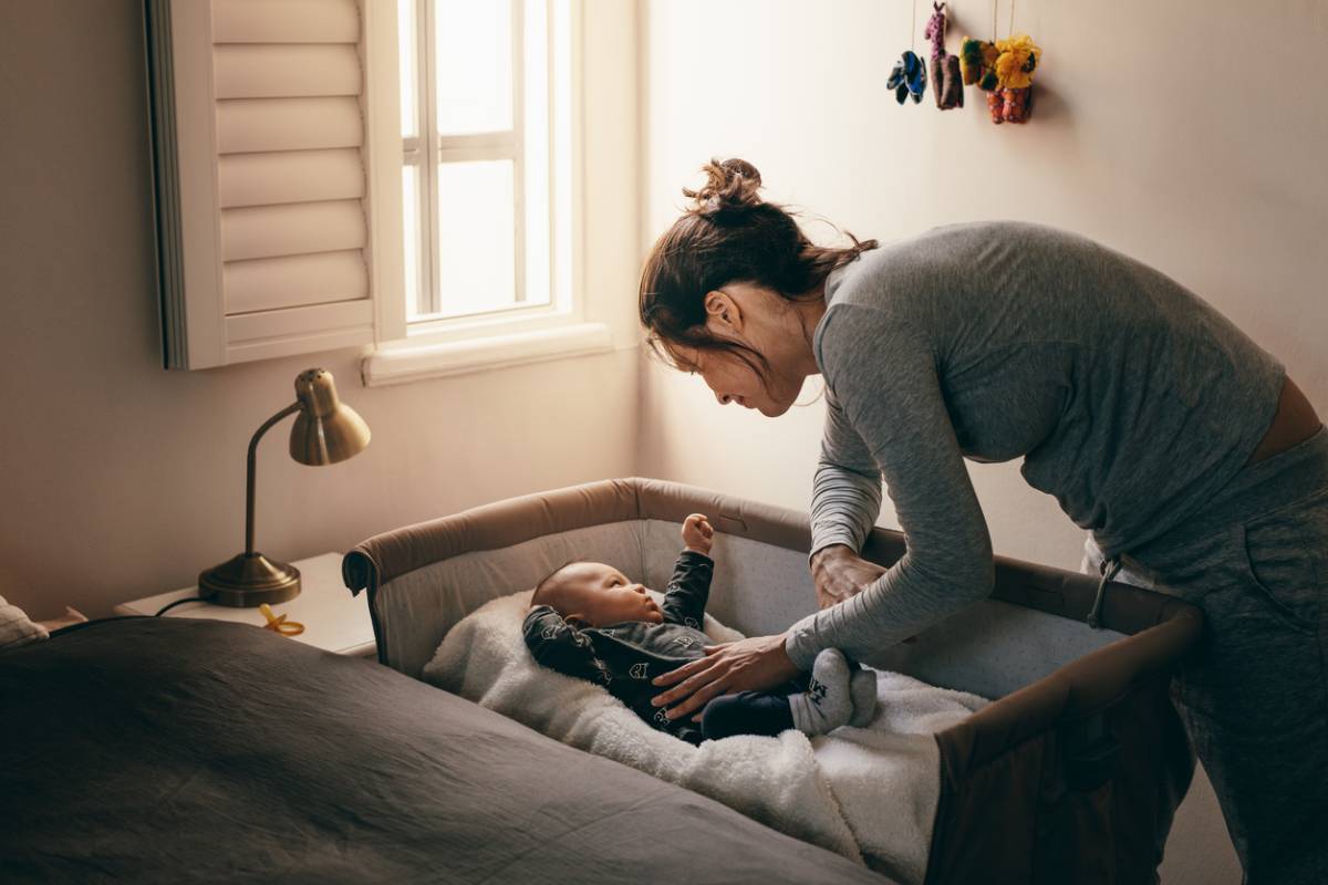 Woman putting her child to bed for sleep