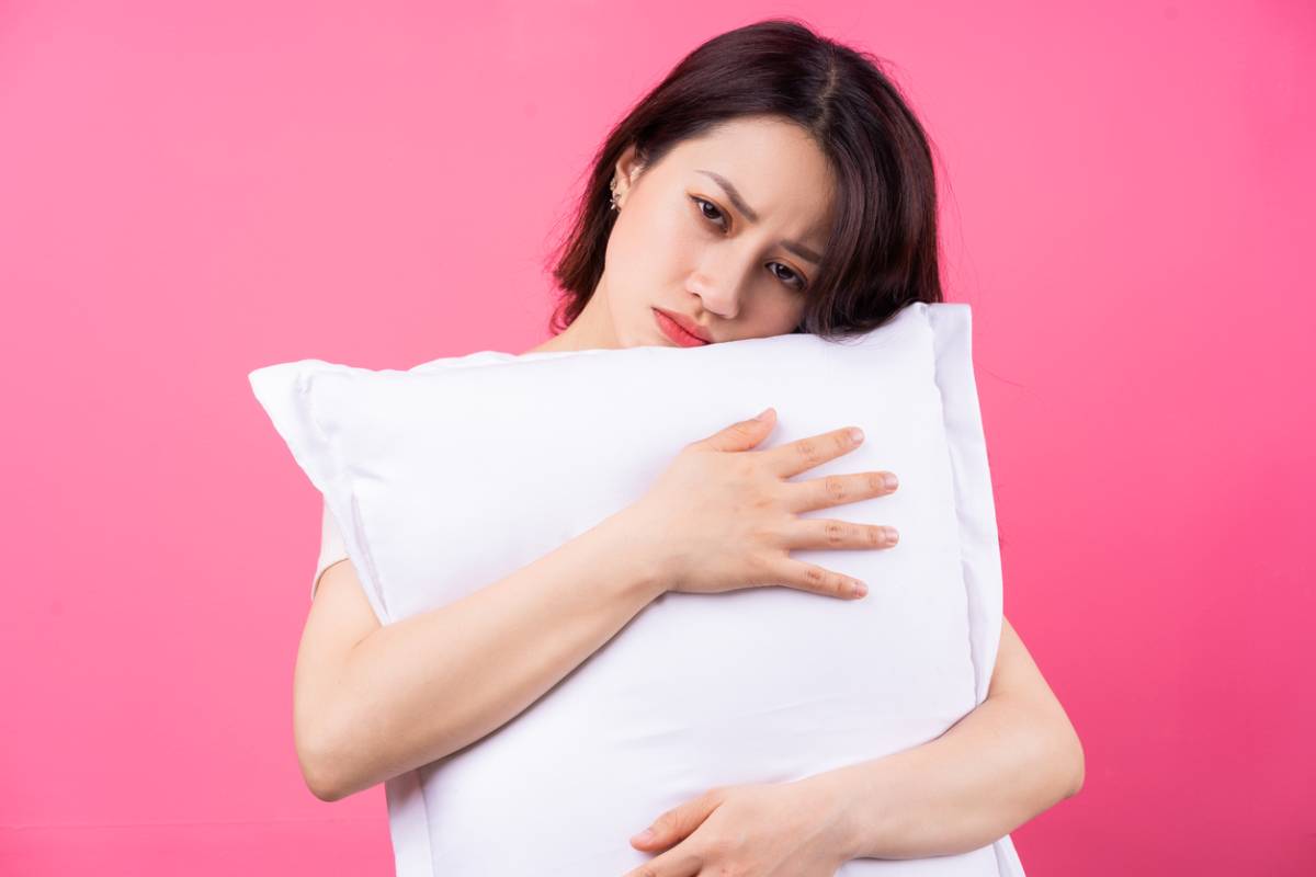 woman hugging her pillow which may be ruining her sleep