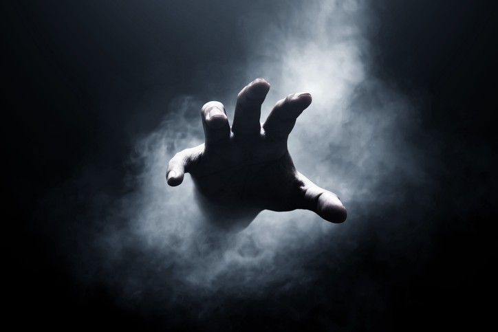 An image of a hand appearing out of mist in front of a dark background as the featured image for Why Do People Have Nightmares